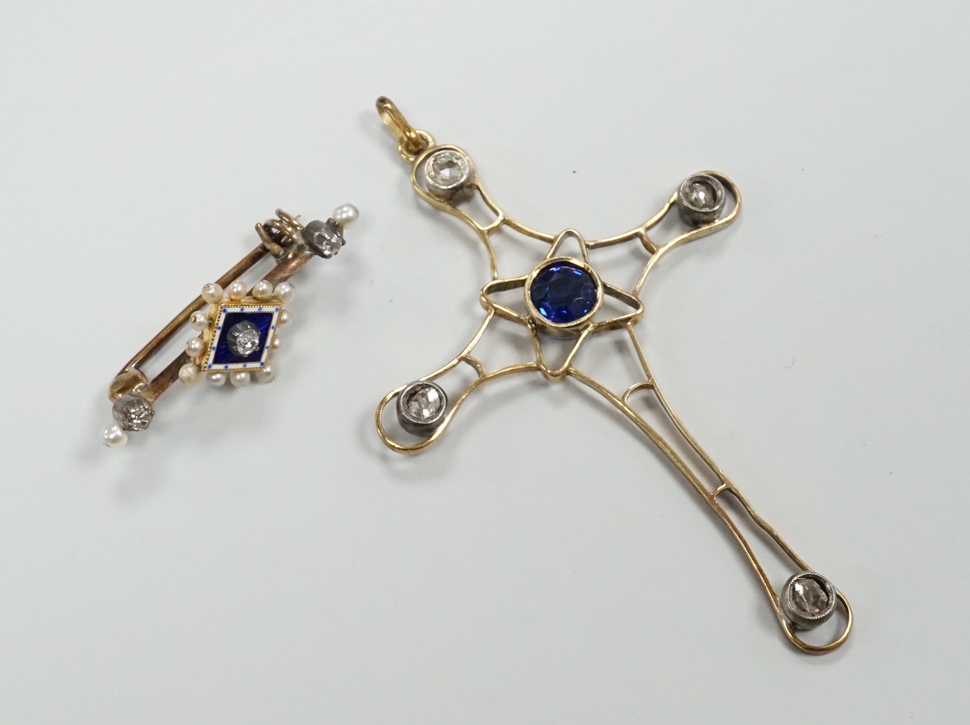 An Edwardian yellow metal, enamel and diamond chip set brooch, 30mm and a rose cut diamond and synthetic sapphire? set yellow metal cross pendant, gross weight 6.8 grams.